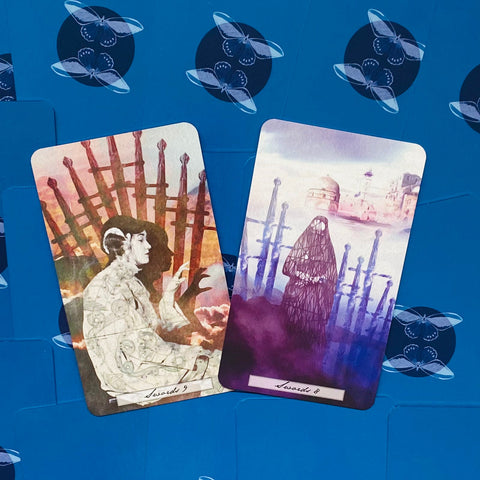 tarot kortos, dvi kortos iš arti: Swords 9 su rausvai‑oranžiniais tonais ir Swords 8 violetinėmis, nufotografuotos iš viršaus ant mėlyno fono
