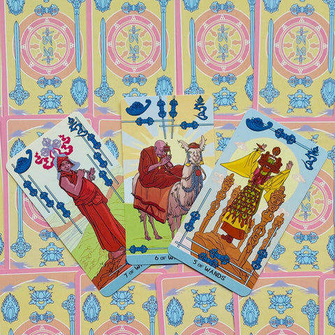 Tarot kortos su pastelinių nugarėlių raštais, atverstos priešiniu kampu: 5, 6 ir 7 Lazdų kortos, detalus dizainas
