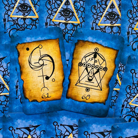 Tarot kortos mėlynomis nugarėlėmis, dvi atverstos kortos nr. 60 ir 61 su sendinto pergamento simboliais, arti nuo viršaus