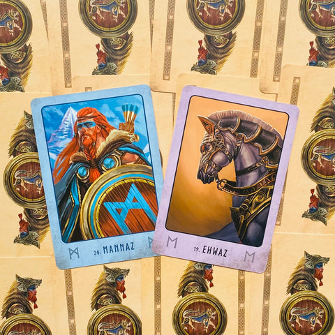 Rūnų kortos, mėlyna Mannaz ir violetinė Ehwaz centre ant fono su pakartotu skydų ir vikingų raštu