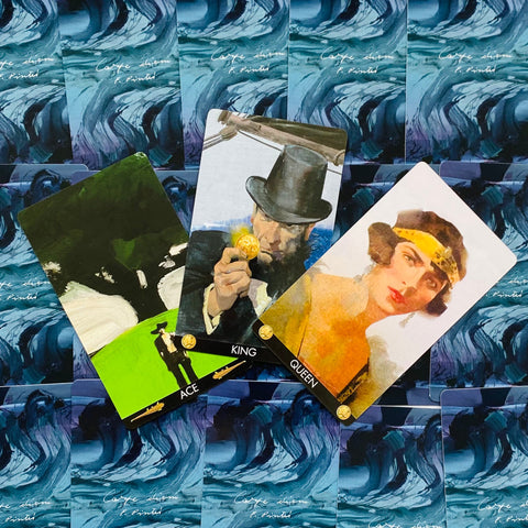 Tarot kortos atverstos ant mėlynų bangų nugarėlių, centre King su auksine moneta, kairėje Ace žalia fone, dešinėje Queen portretas