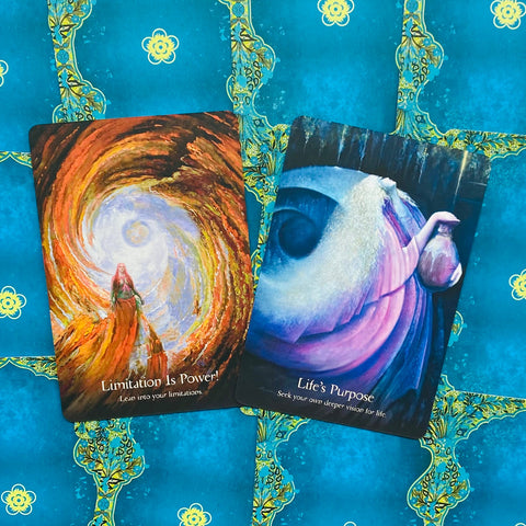 Tarot kortos su ryškiomis mistinėmis iliustracijomis — dvi kortos plokščiai ant mėlyno ornamentuoto fono