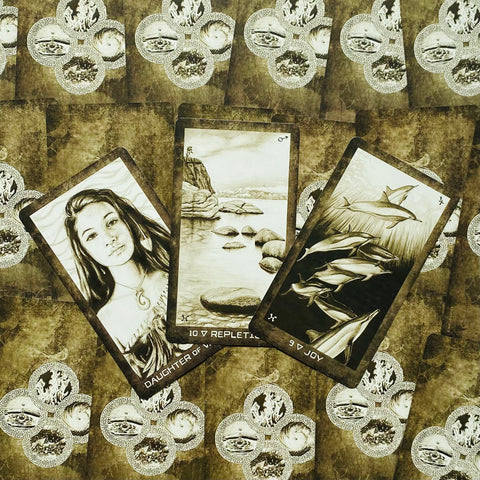 tarot kortos sepia iliustracijų rinkinys, atverstos trys kortos (merginos, akmenuoto kranto, delfinų) ant fono, pasvirusi perspektyva