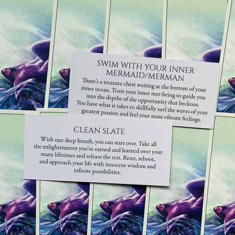 Oracle kortos su purpurine undinės iliustracija ir dviem žinutėmis – „Clean Slate“ ir „Swim With Your Inner Mermaid“, kortos išdėstytos sluoksniais
