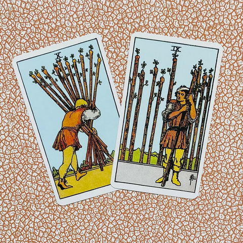 Tarot kortos Rider–Waite, 10 ir 9 Lazdų variantai, kortų priekinės pusės matomos ant rožinio–balto tekstūruoto fono