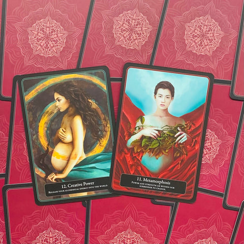 Tarot kortos atverstos: 11 Metamorphosis ir 12 Creative Power ant raudono mandalos fono, turkio ir aukso akcentai