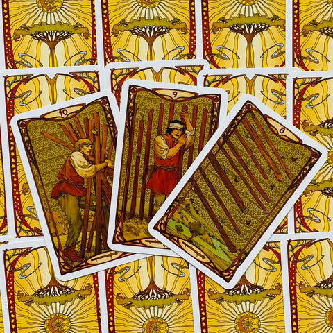 Tarot kortos su Lazdų rūšies (8, 9, 10) kortomis ir geltonai-raudonu atgaliniu raštu, išskleistos fanu ir pateiktos kaip variantas