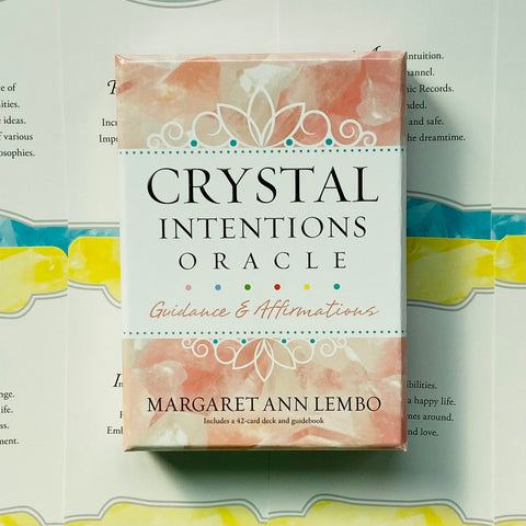 Crystal Intentions oracle kortos Margaret Ann Lembo, rausvai‑baltame dėkle, komplekte 42 kortos ir gido knygutė, pavaizduota iš priekio