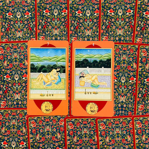 tarot kortos su oranžiniais rėmeliais, dvi atverstos erotinės iliustracijos pažymėtos 3 ir 4, likusi kaladė uždengta raštuotais nugarėliais