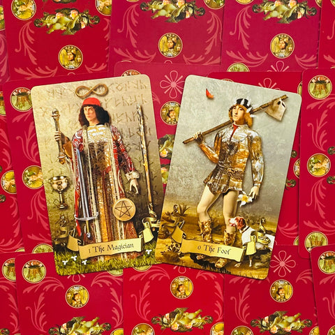 Tarot kortos — du atviri klasikinių piešinių major arcana kortelės (The Magician, The Fool) ant raudonų galinių kortų