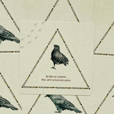 Plakatas su juodu varnėnu trikampiniame auksuotu raštuotu rėmelyje ant smėlinio fono, centre matomas angliškas tekstas Be light as a feather