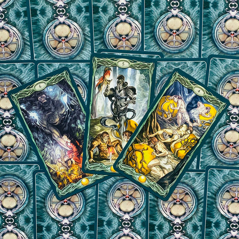 Tarot kortos su žaliais rėmeliais ir turkio nugarėlėmis, trys atvertos kortos fanuotos, demonstruoja skirtingas interpretacijas