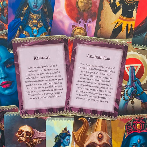 orakulų kortos su violetinėmis nugarėlėmis ir dviem atverstomis paaiškinamomis kortelėmis, parodyta artima detalė