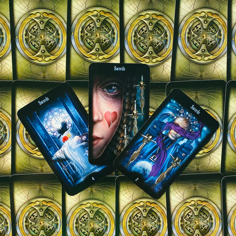 Tarot kortos Swords rinkinys: trys atverstos kardų kortos su artimu portreto motyvu ir žalvario nugarėlės raštu