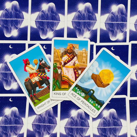 Tarot kortos Rider‑Waite stiliaus: trys atverstos Pentaklių kortos (Knight, King, Ace) spalvingame flat‑lay ant mėlyno žvaigždėto nugarėlių fono