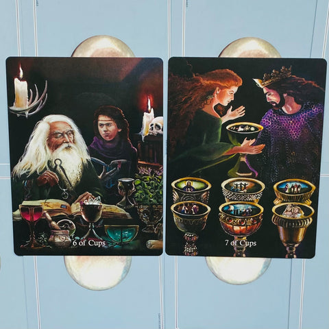 Tarot kortos, dviejų kortų (6 ir 7 Cups) priekinė pusė, tamsūs iliustruoti dizainai, artimas detalus kampinis rodinys