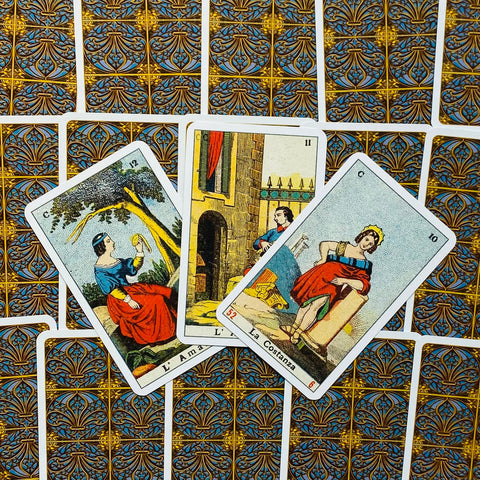 Tarot kortos vintažinių itališkų iliustracijų, trys atrinktos kortos išdėstytos iš priekio ant ornamentuoto nugarėlių fono, ryškios spalvos ir detalės