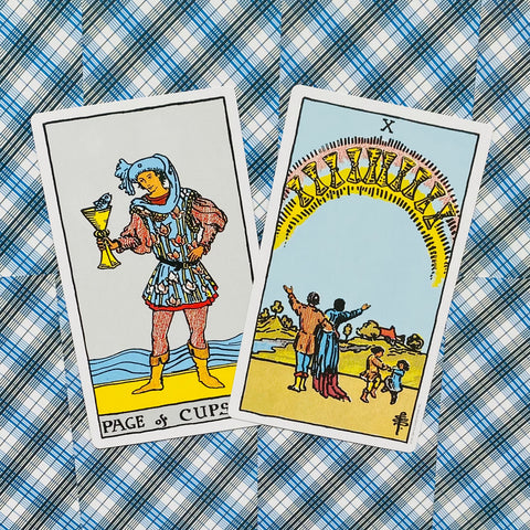 tarot kortos Rider–Waite komplektas, dvi atviros kortos (Page of Cups, Ten of Cups) plokščiu kampu ant mėlyno languoto fono