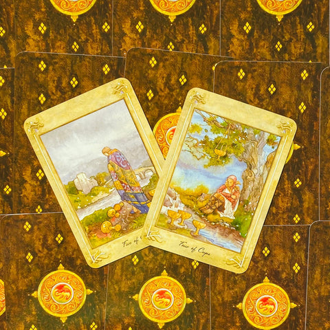 tarot kortos – dvi atverstos taurų kortos (Keturi ir Penki) ant tamsaus ornamentuoto nugarėlių fono, akvareliniai piešiniai