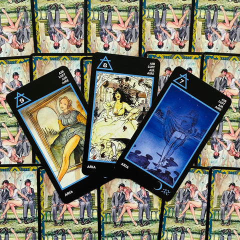 Tarot kortos juodu rėmeliu su mėlynomis detalėmis, trys atidengtos iliustruotos kortos virš kartotinės nugarėlės