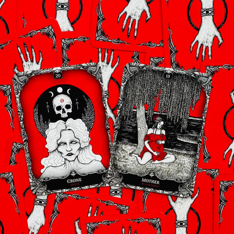 Tarot kortos rinkinys su ryškiai raudonomis nugarėlėmis ir dviem atverstomis juodai baltomis kortomis Crone (Mirtis) ir Mother (Išsipildymas), skirtas burtams ir dekorui