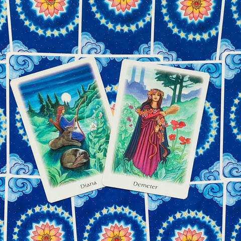Tarot kortos atverstos: Dianą ir Demeter kortos ant mėlyno žvaigždėto nugarėlio, ryškios detalių iliustracijos