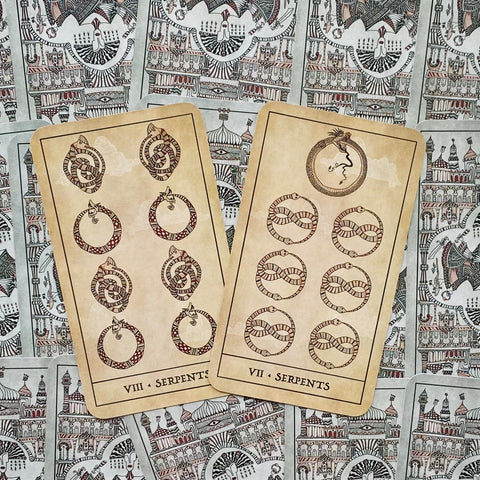 tarot kortos Serpents komplektas — dvi rudos senovinio stiliaus kortos (VII ir VIII) išdėstytos ant dekoratyvių nugarėlių fono