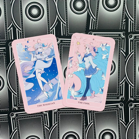 tarot kortos rožiniu kraštu — anime stiliaus Major Arcana „The Magician“ ir „The Fool“ išdėstytos ant juodo raštuoto fono