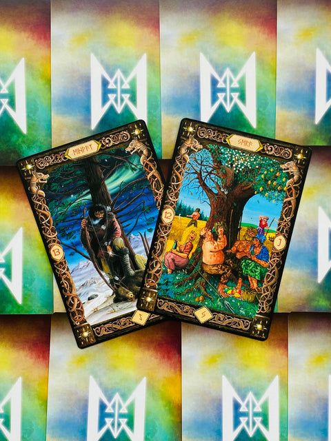 Tarot kortos su ryškiomis iliustracijomis, dvi atvertos kortos: vienoje klajūnas žiemoje, kitoje vasaros šventė