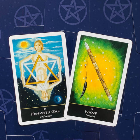 tarot kortos, dvi demonstracinės kortos su mėlyna Six‑Rayed Star ir žalia Wand iliustracijomis, kampinis kadravimas ant tamsaus fono, variantas be dėžutės