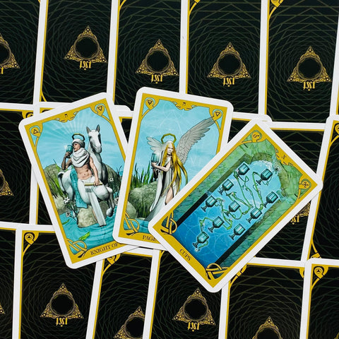 Tarot kortos su mėlynais ir auksiniais rėmais, trijų atverstų kortų fanuota kompozicija, pabrėžianti individualias iliustracijas