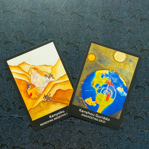 Tarot kortos dviejų kortų rinkinys: geltoni kalnų motyvai ir mėlyna žemėrutulio iliustracija, pateiktos pasvirusiu kampu