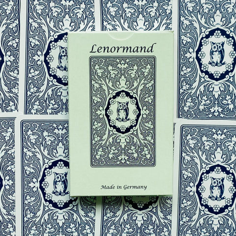 Lenormand kortų rinkinys mintinės dėžutės centre ant mėlynai baltų nugarėlių su pelėdos motyvu, pagamintas Vokietijoje