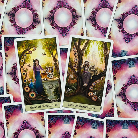 Tarot kortos devyni ir dešimt pentaklių su spalvingomis iliustracijomis ir rožinėmis nugarėlėmis, parodyta iš viršaus