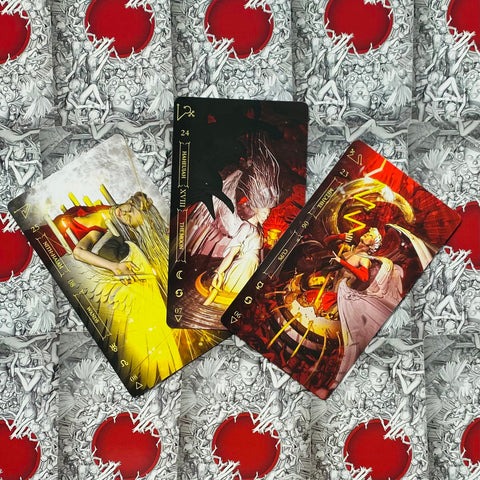 Tarot kortos su trimis spalvingais arkų piešiniais — raudono, geltono ir tamsaus motyvų komplektas ant dekoratyvaus raudonai–pilko fono