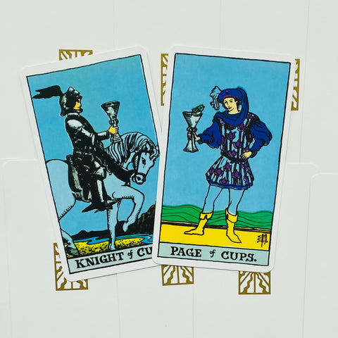 tarot kortos Rider–Waite: dvi atviros kortos (Knight of Cups ir Page of Cups) ant baltos fono, persidengiančios viena ant kitos