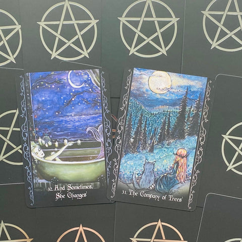 tarot kortos – dvi iliustruotos kortos And Sometimes She Changes ir The Company of Trees ant juodo pentagramų fono, skirtingos mėlynos naktinės scenos