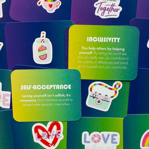 Motyvacinių kortelių rinkinys žaliai‑mėlynomis kortelėmis su „Self‑acceptance“ ir „Inclusivity“ tekstais, lipdukai šonuose, rodoma iš priekio