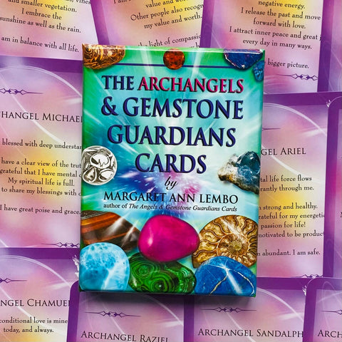 angelų kortos Archangels & Gemstone Guardians Margaret Ann Lembo, spalvota dėžutė su akmenų motyvais ant violetinių afirmacijų kortelių fono