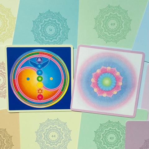Meditacijos kortos, dvi atviros kortos su mėlyna čakrų yin‑yang ir pasteline gėlių mandala, artimas planas