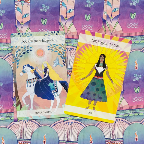 Tarot kortos, dvi atviros priekinių iliustracijų versijos — ryški geltonoji The Sun ir pastelė Judgment ant violetinio rašto fono
