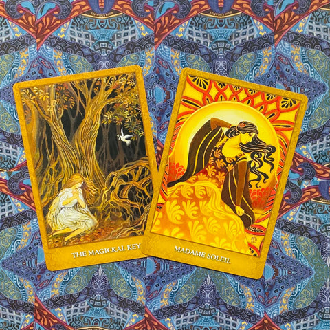 tarot kortos, dvikartis rinkinys su The Magickal Key ir Madame Soleil aukso rėmeliais ant mėlyno raštuoto fono