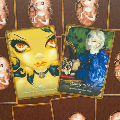 Tarot kortos ant stalo, dvi atverstos kortos — geltona Witness ir mėlyna Burnt by the Sun, meninės iliustracijos
