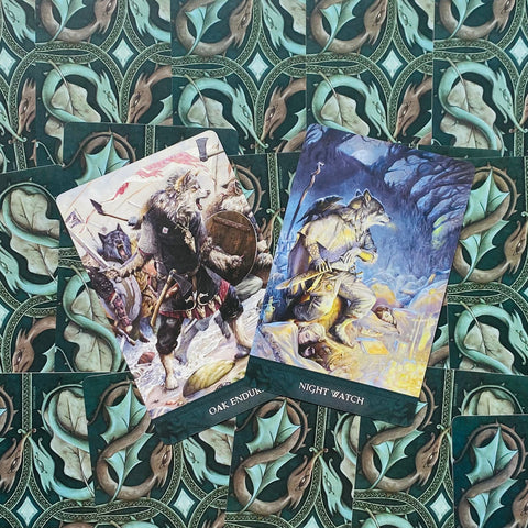 Tarot kortos su atverstu „Oak Endurance“ ir „Night Watch“ dizainu, detalūs iliustruoti priekiniai vaizdai ir žalios ornamentuotos nugarėlės