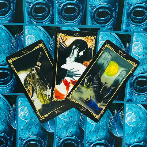 Tarot kortos fanuotos trijų atvirų kortų rinkinys su tamsiais rėmeliais ir ryškiomis mėlynomis nugarėlėmis