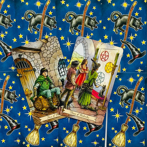 Tarot kortos ant mėlyno žvaigždėto fono su katėmis ir šluotomis, dvi atverstos kortos – Trys ir Keturi Pentakliai, iliustruota sceninė kompozicija