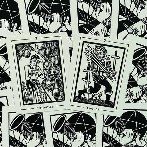 tarot kortos juodai baltos, artimas kampinis kadras su dviem atviromis kortomis (7 Pentacles ir 7 Swords)