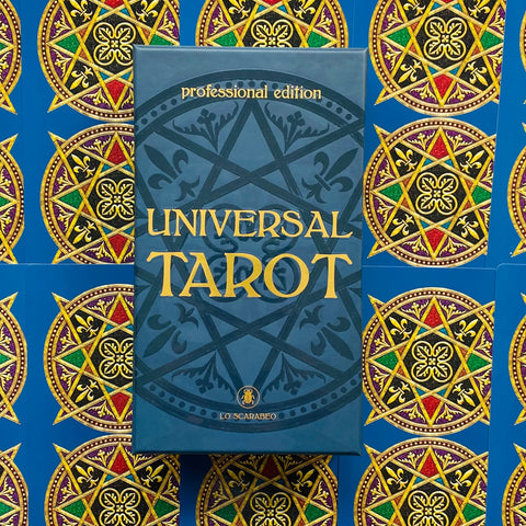 Lo Scarabeo Universal Tarot mėlyna stačiakampė dėžutė, stačia orientacija, prie ornamentuoto mėlyno ir aukso fono