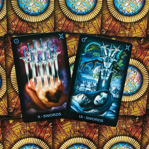 tarot kortos Illuminati leidimas, tamsiai mėlynos ir raudonos X ir IX Kalavijų kortos, detalus artimas kampinis kompozicija, matomas ir galinis raštas