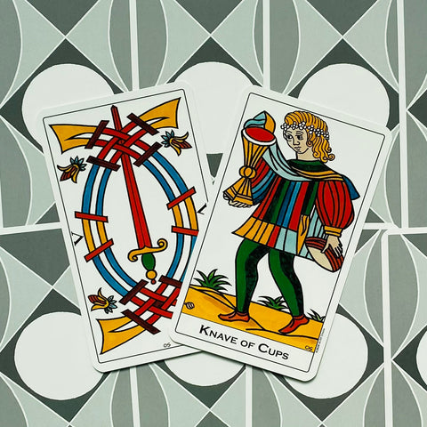 Tarot kortos Marseille stiliaus, plokščiai išdėstytos: rodomas Taurių Riteris ir ornamentuota nugarėlė su ryškiomis spalvomis